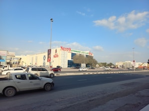 a car driving down a street next to a tall building