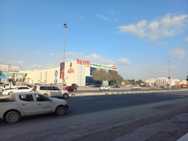 a car driving down a street next to a tall building