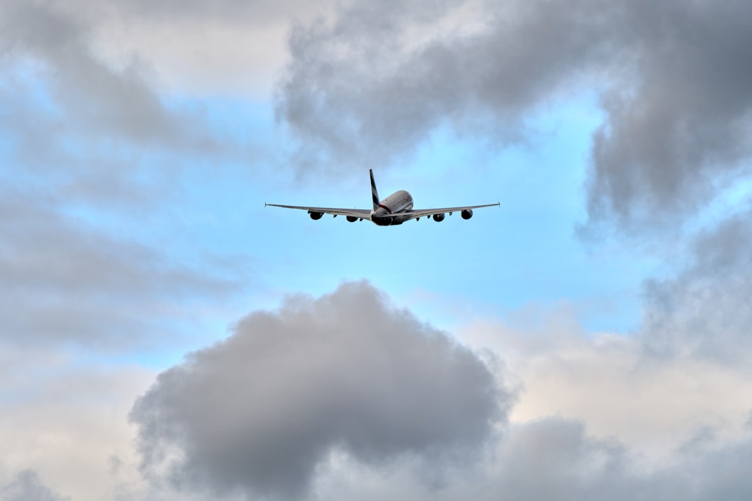 an airplane flying through a cloudy blue sky,