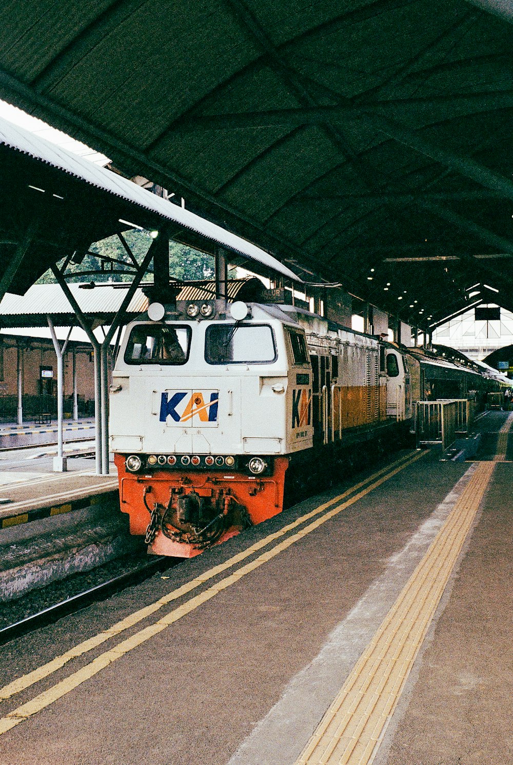 Un tren que se detiene en una estación de tren junto a un andén