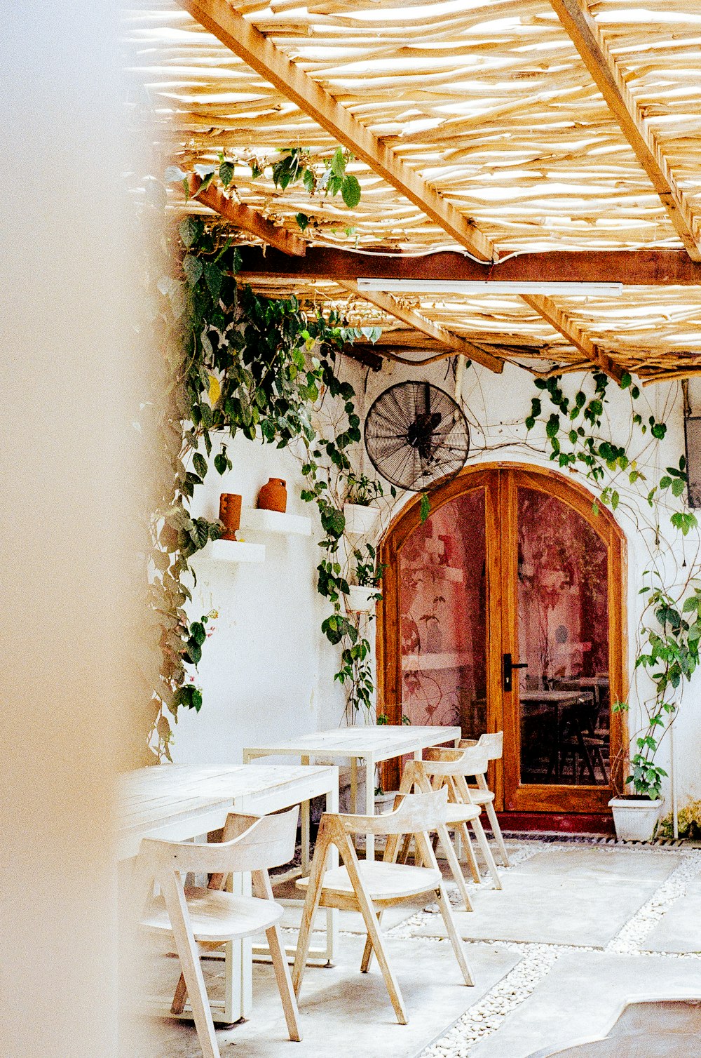 a patio with a table and chairs and a fan