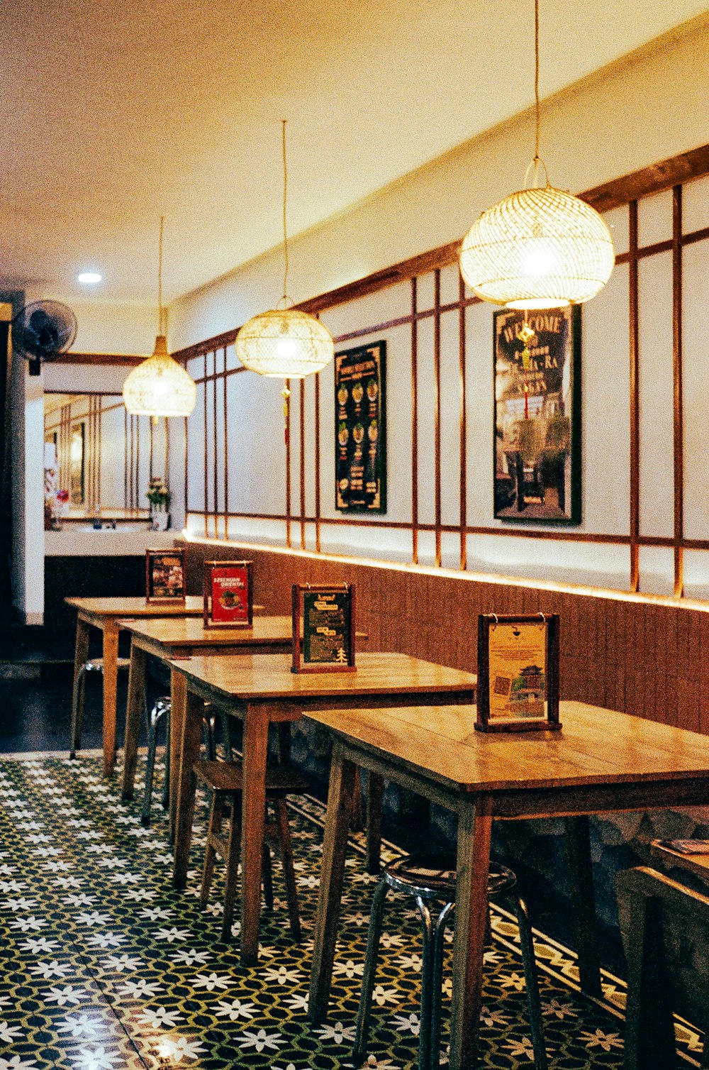 a row of tables in a restaurant with pictures on the wall