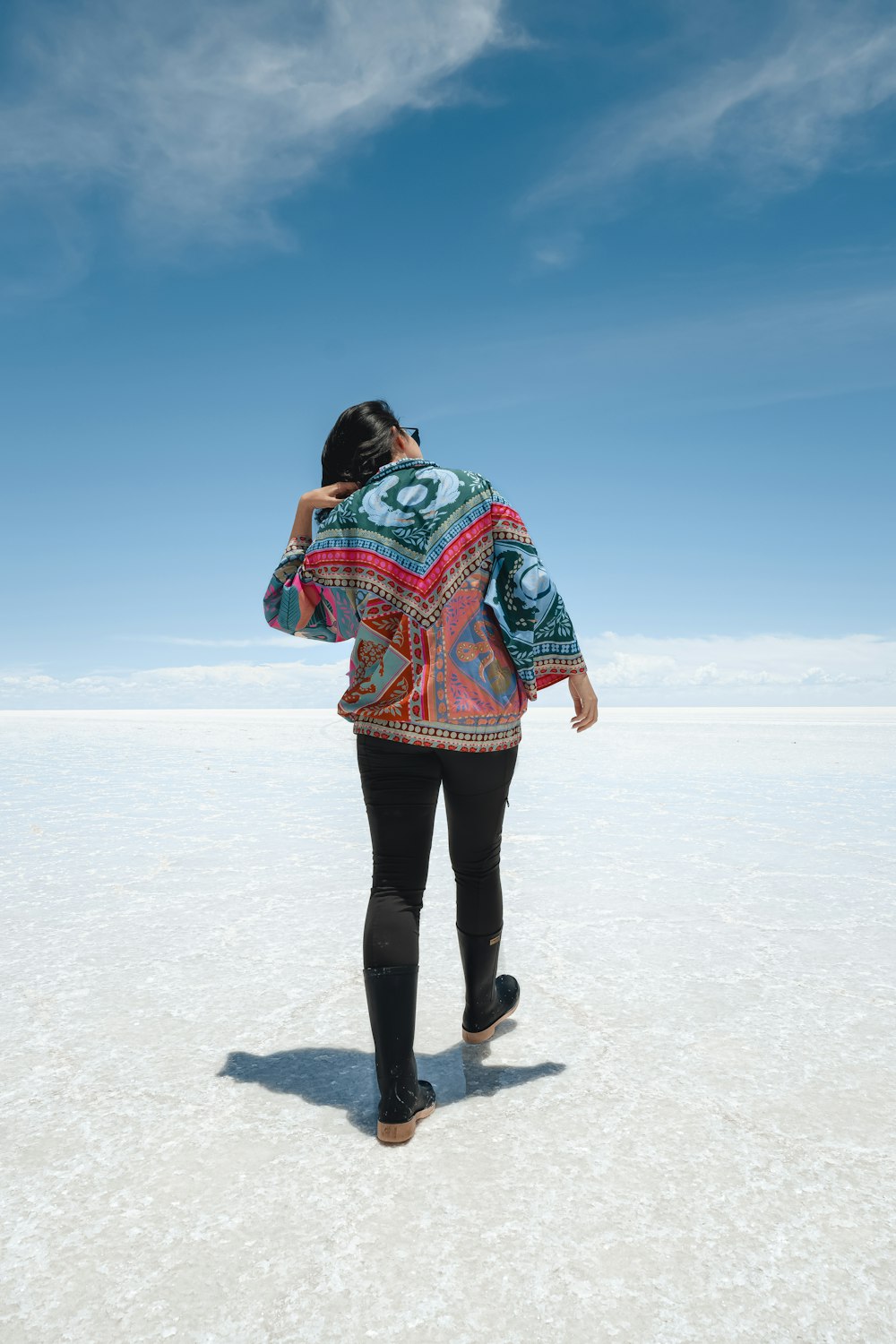 a woman walking across a snow covered field