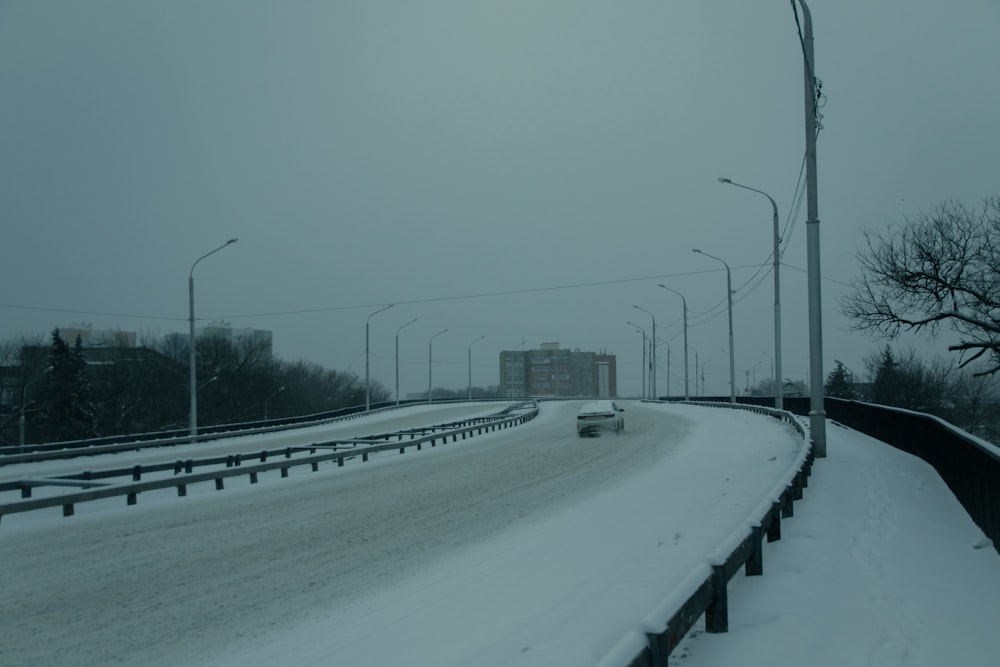 uma estrada nevada com luzes de rua e lâmpadas de rua
