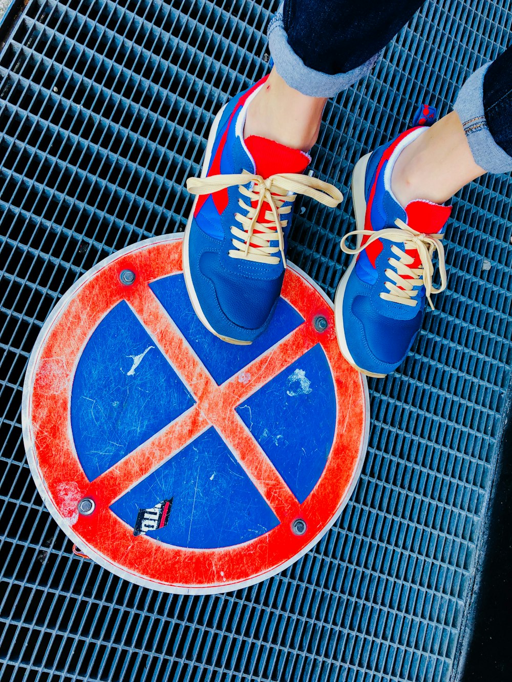 a person standing on top of a blue and red sign