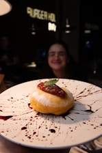 a person holding a plate with a pastry on it