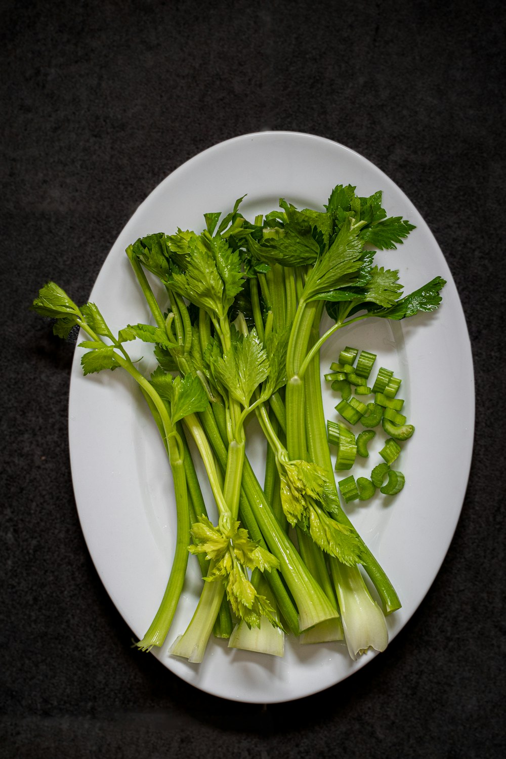 une assiette blanche garnie de légumes verts sur le dessus d’une table