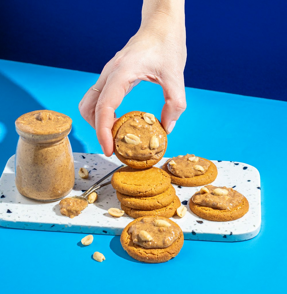 a person picking up a cookie from a tray
