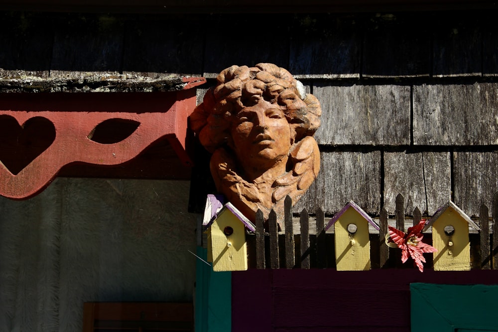 una estatua de la cabeza de una mujer en el costado de un edificio