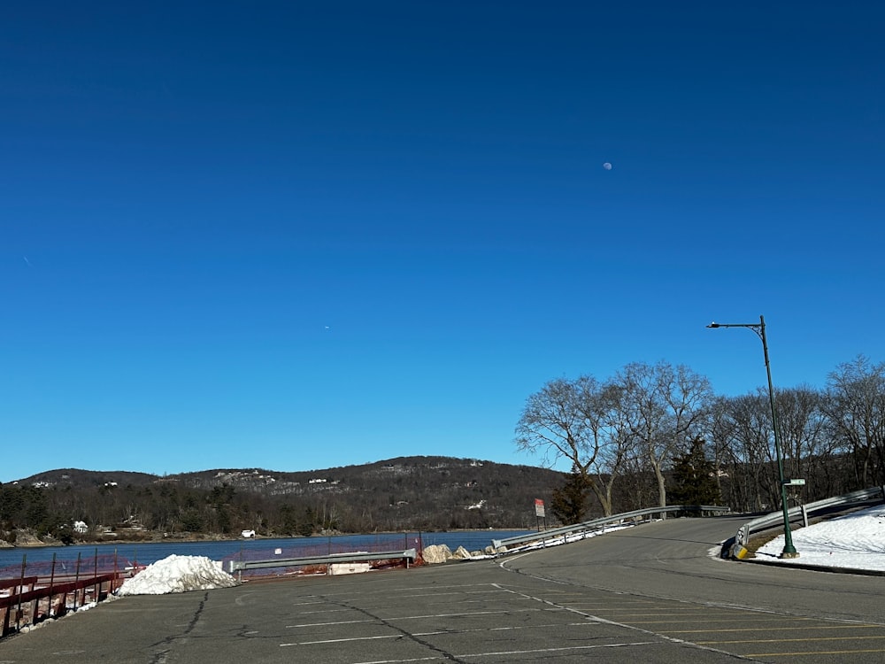 an empty parking lot next to a body of water