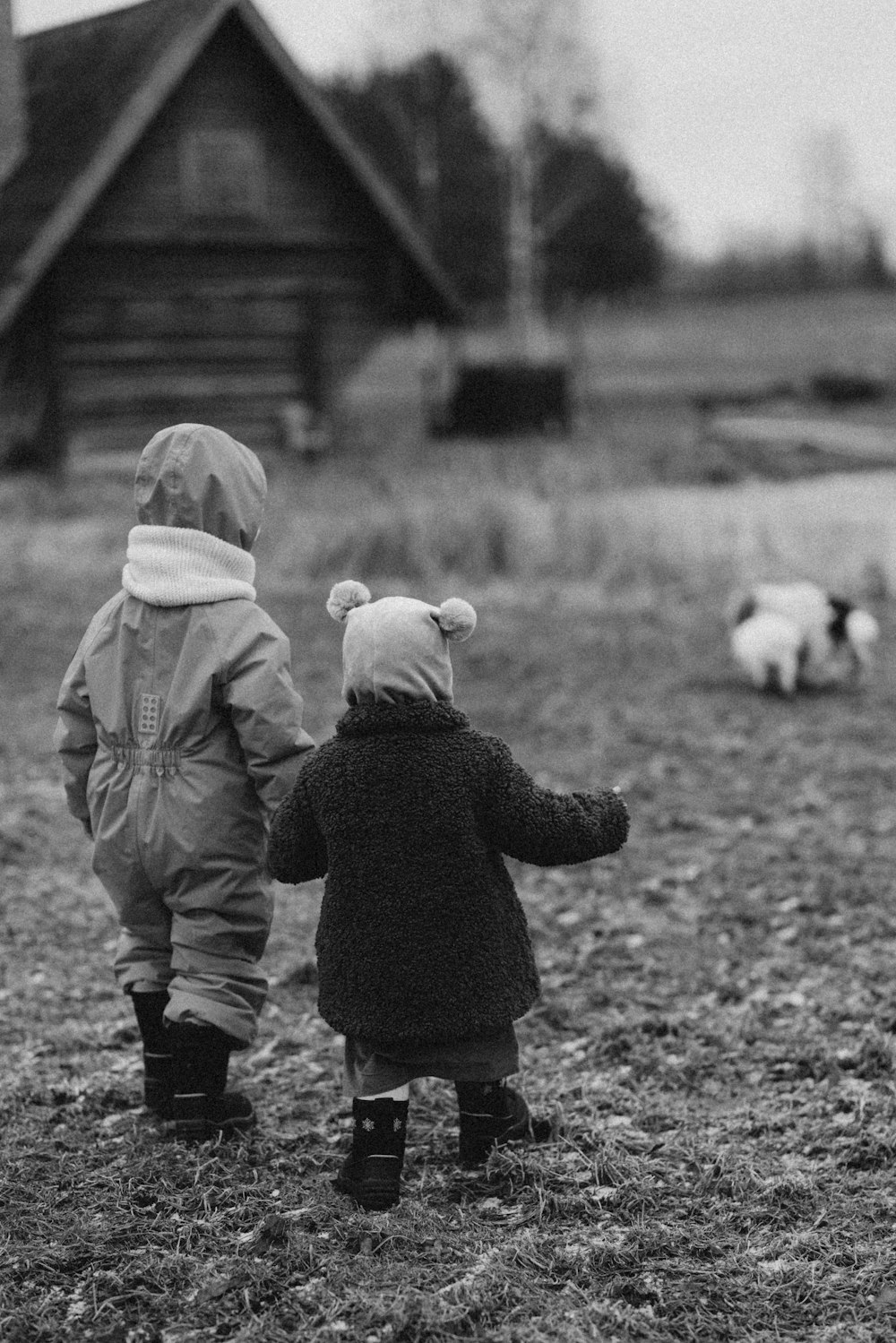 two small children are standing in a field