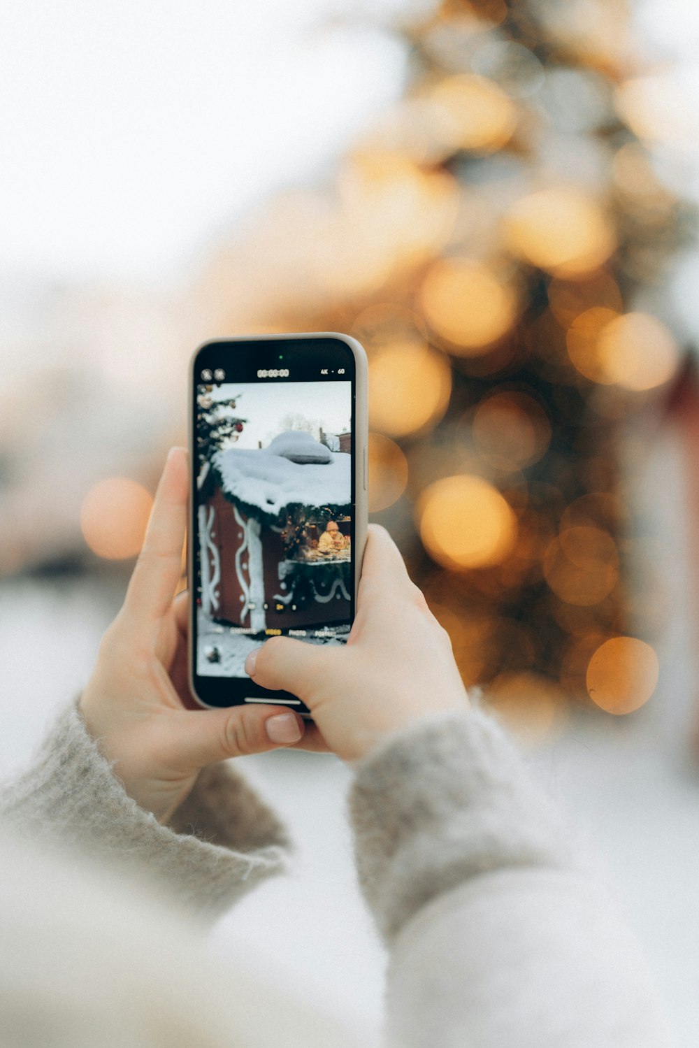 Una persona tomando una foto de un árbol de Navidad