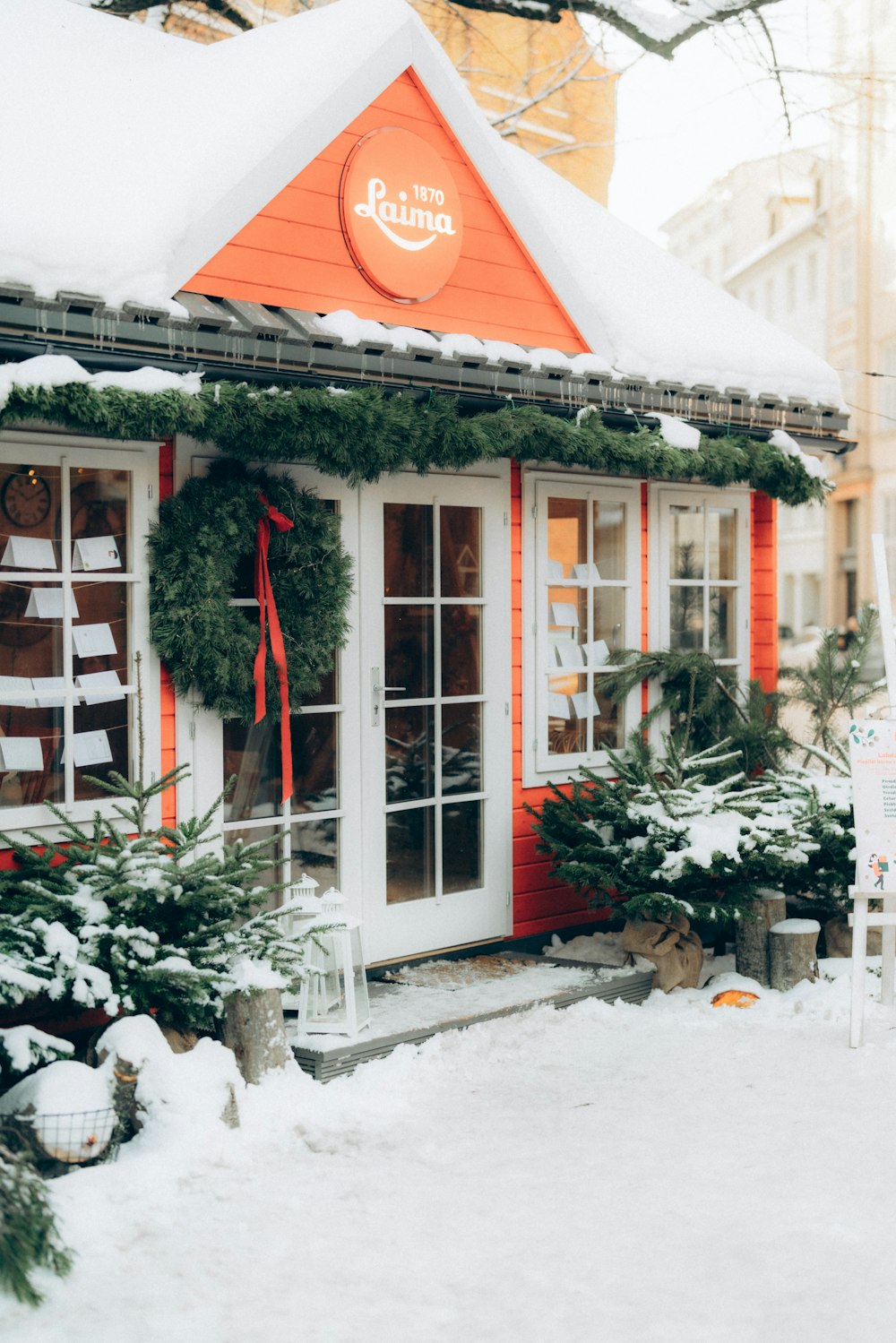 a small orange and white building with wreaths on it