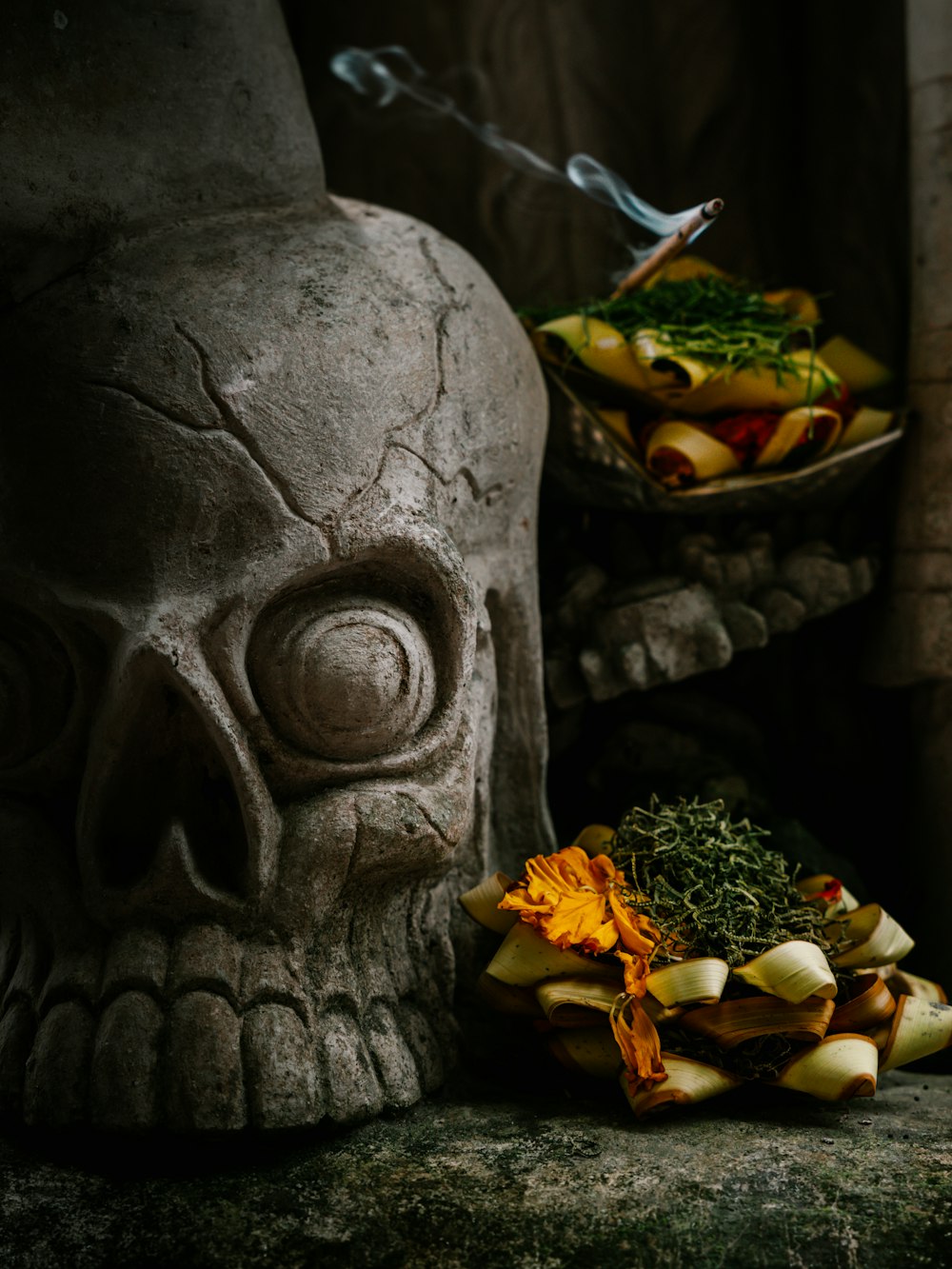 a skull statue sitting next to a bowl of food