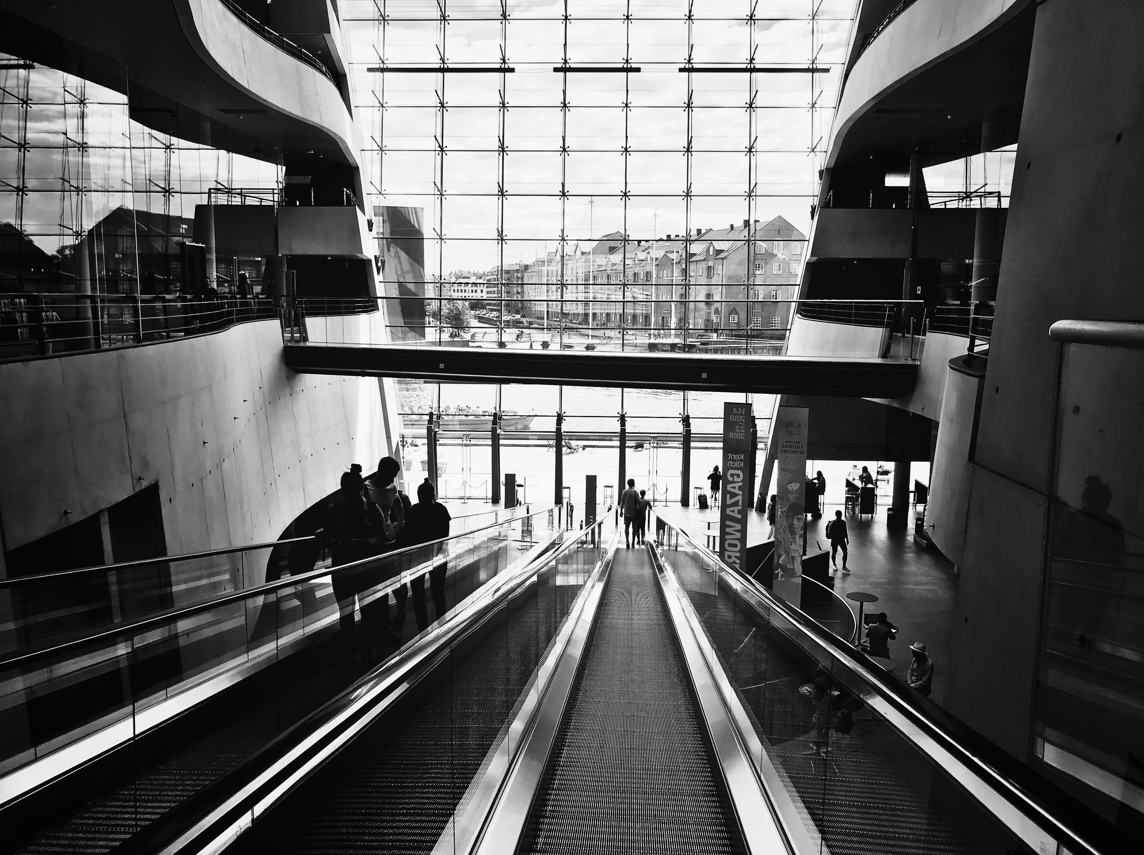 a black and white photo of an escalator in a building, 