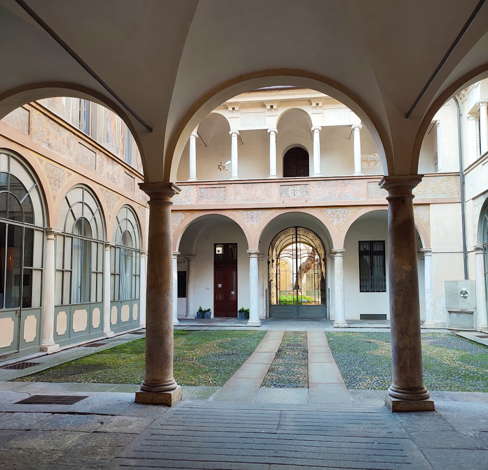 a courtyard with arches and a clock on the wall