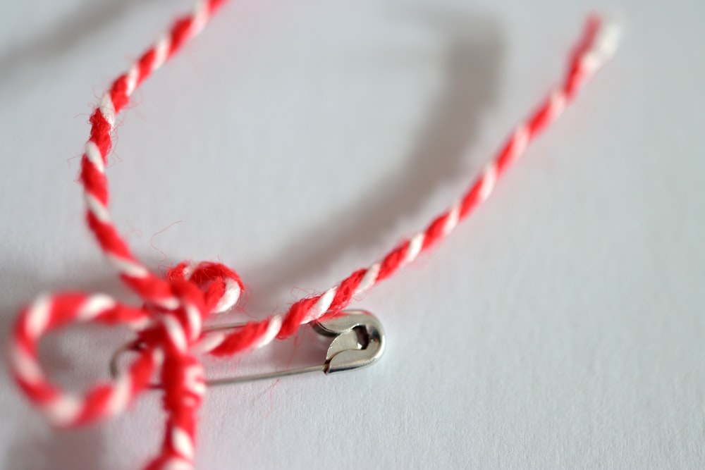 a red and white rope with a metal hook