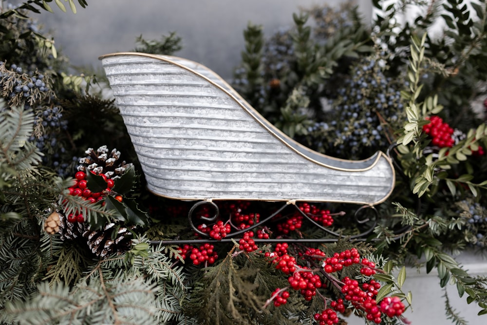 a silver sleigh with red berries and pine cones