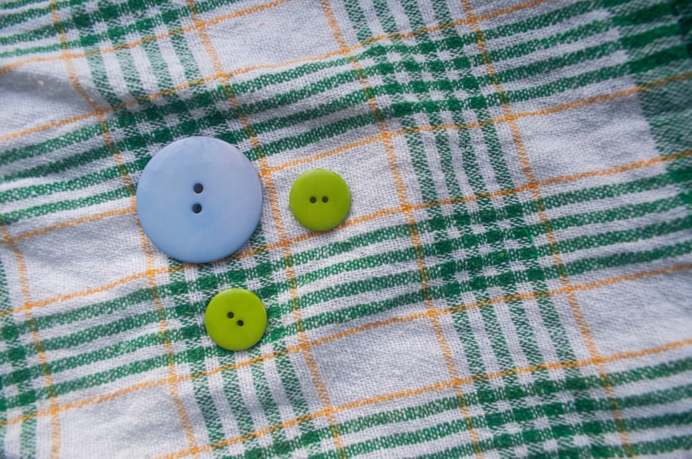 two green and white buttons on a green and white checkered cloth