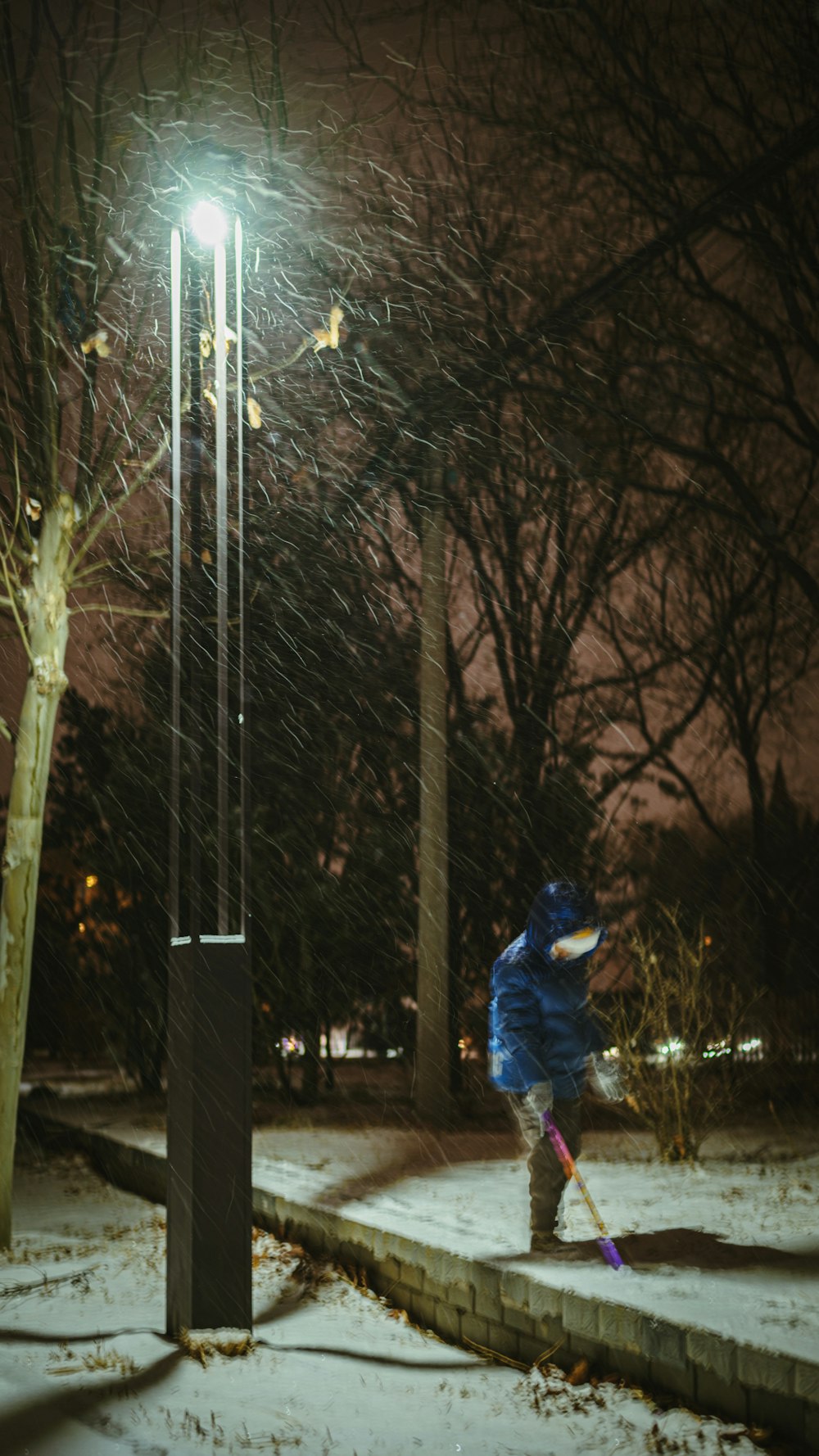 a person in a blue jacket is playing in the snow