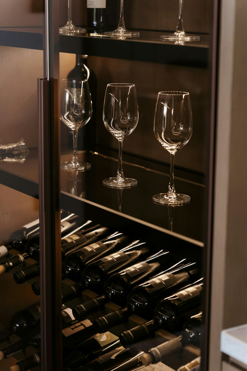 a bunch of wine glasses sitting on a shelf