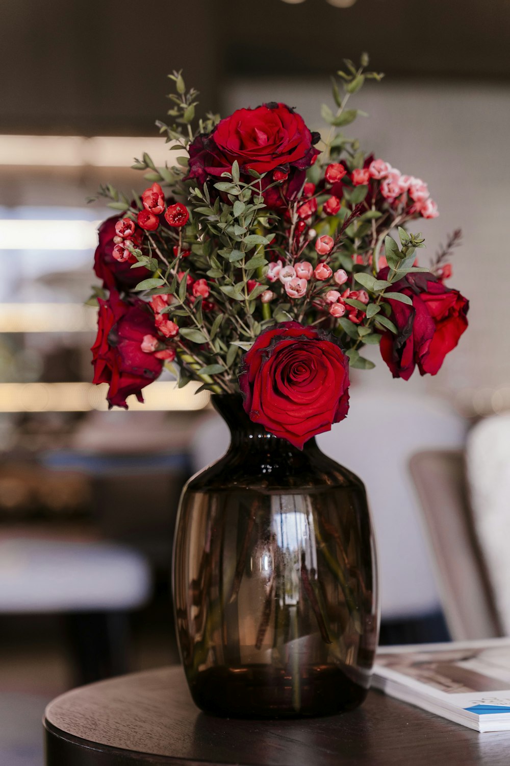 테이블 위에 놓인 빨간 꽃으로 가득 찬 꽃병