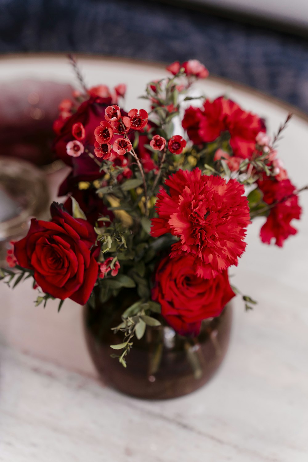 a vase filled with red flowers on top of a table