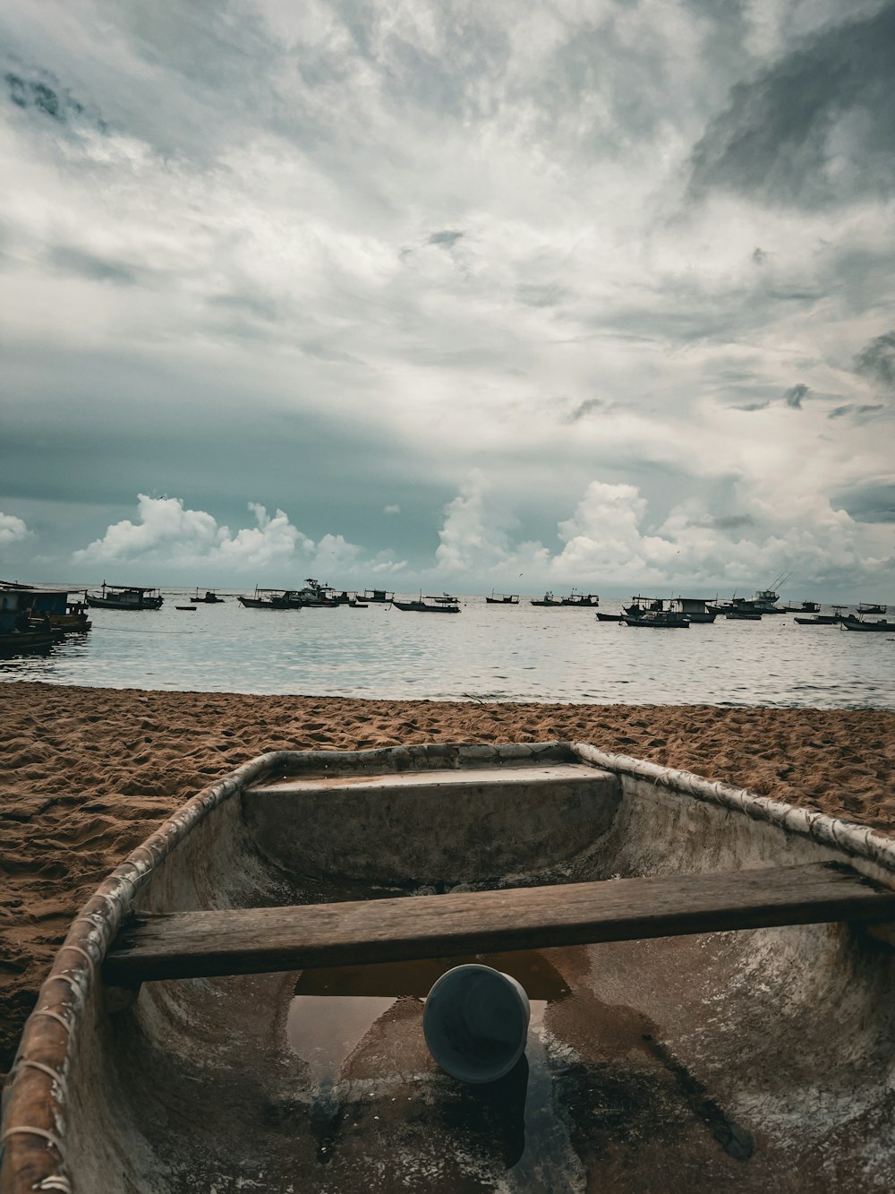 a boat sitting on top of a sandy beach