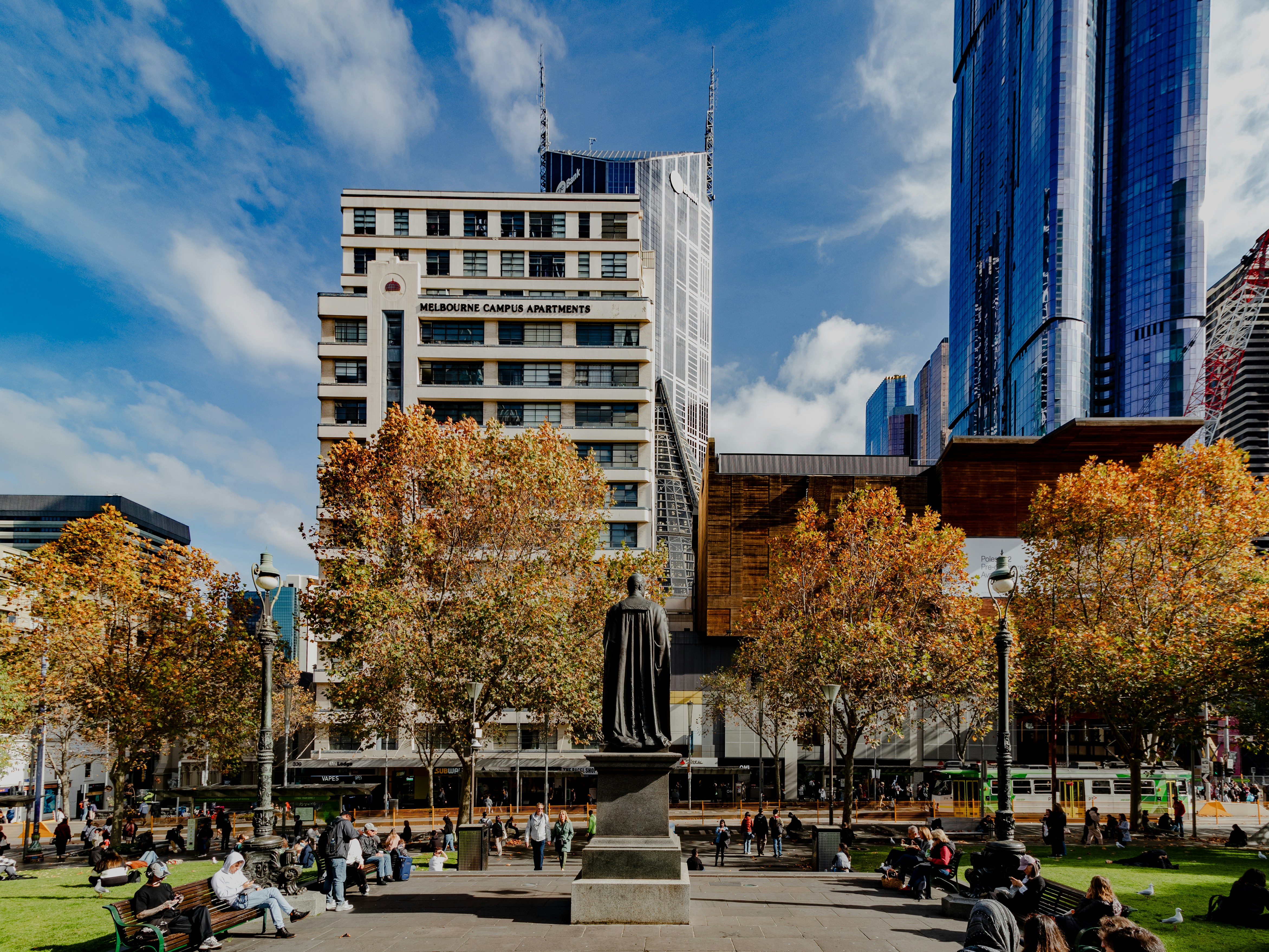 a group of people sitting and standing around a park