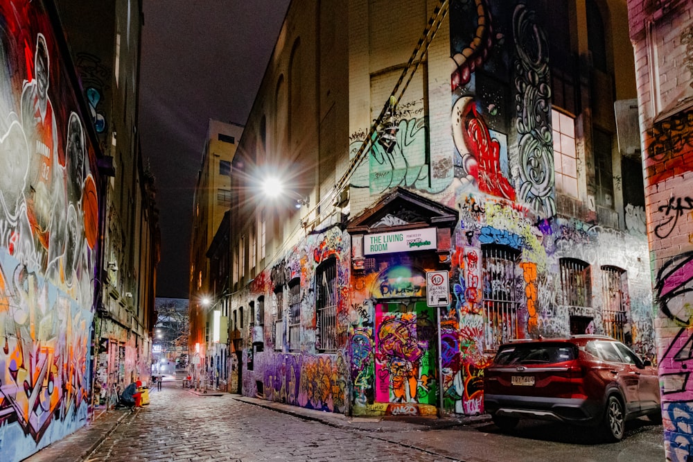 a car parked in front of a building covered in graffiti