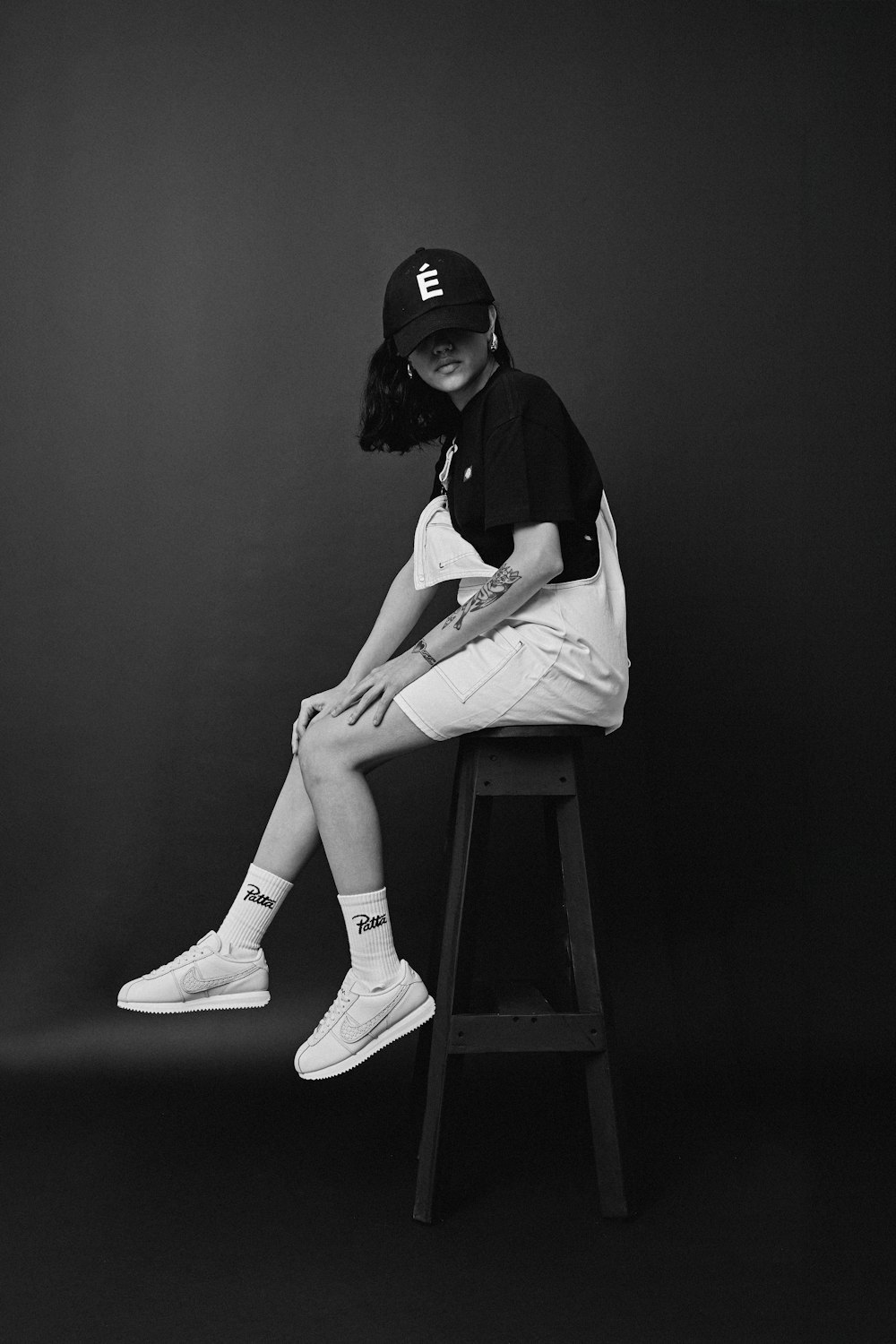 a woman sitting on top of a wooden stool