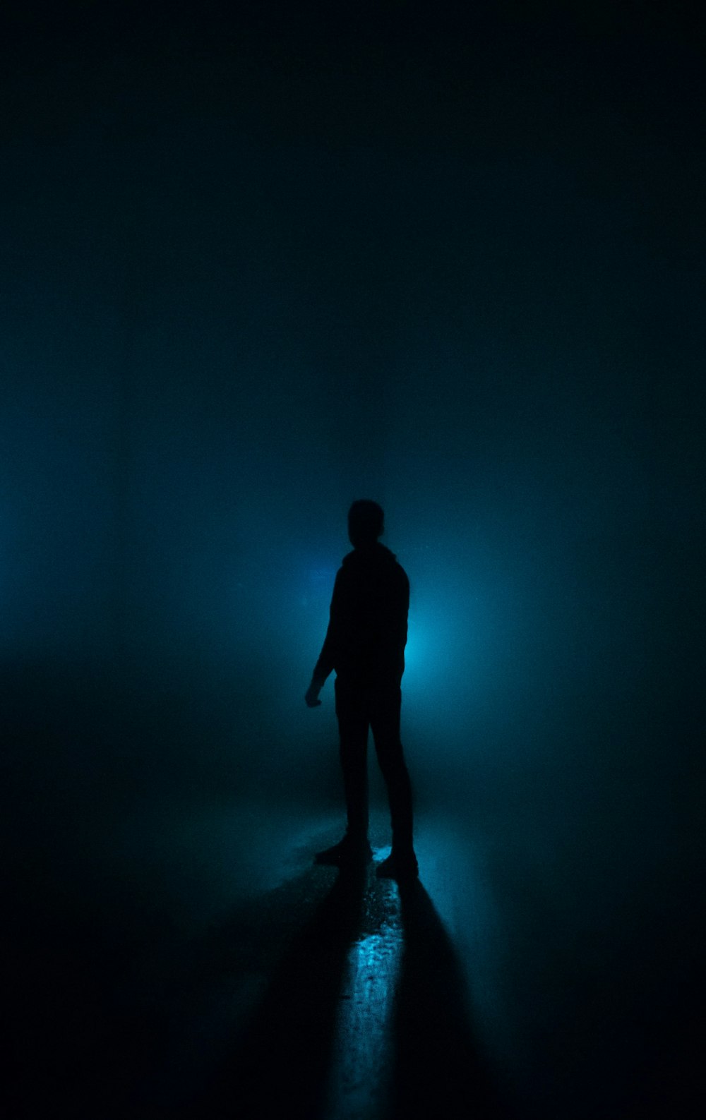 a person standing in a dark room with a light on
