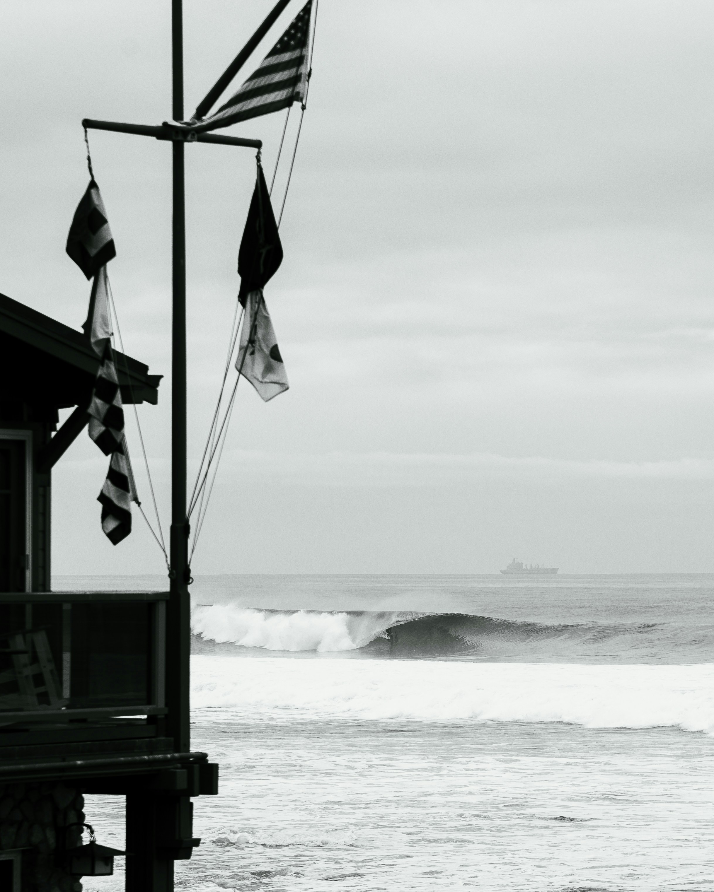a black and white photo of a wave coming in from the ocean