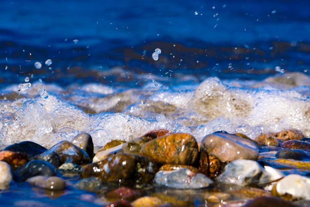 a close up of rocks and water on a beach