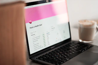 a laptop computer sitting on top of a table next to a cup of coffee