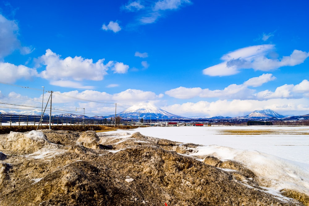 a snow covered field with mountains in the background