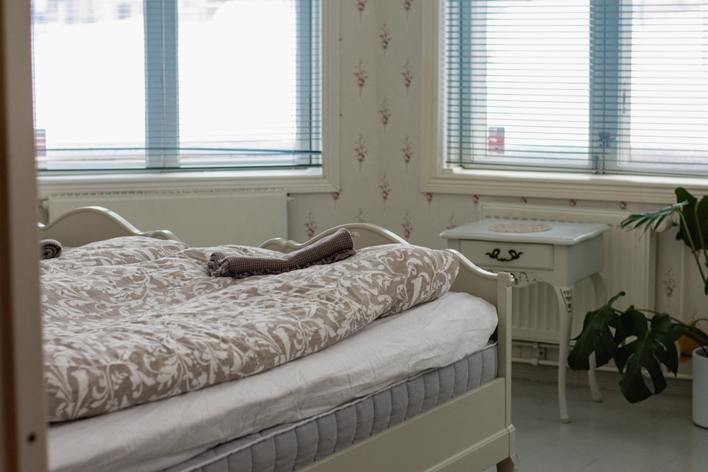 a white bed sitting next to a window in a bedroom