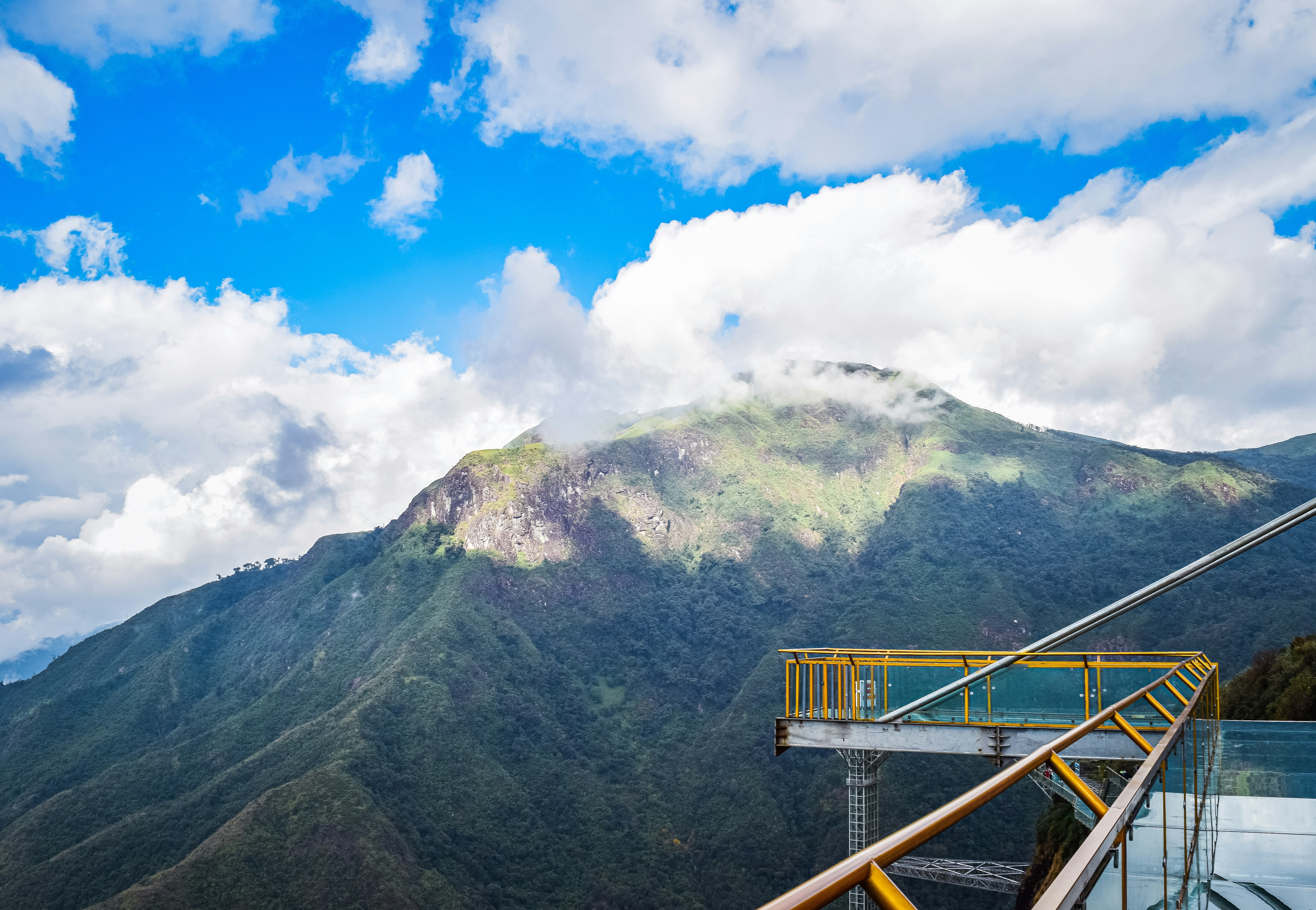 a view of a mountain with a yellow railing