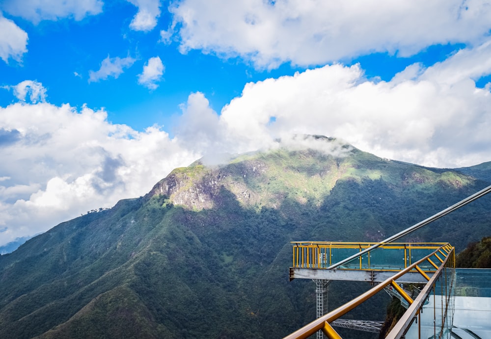 a view of a mountain with a yellow railing