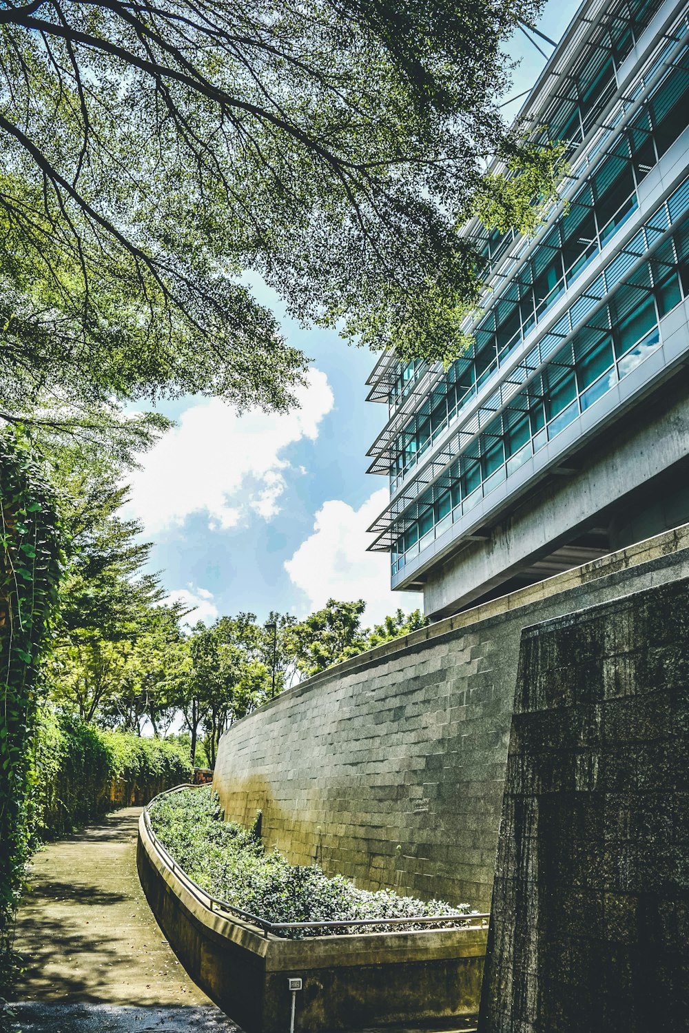 a concrete wall next to a building and trees