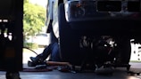 a man working on a vehicle under a truck