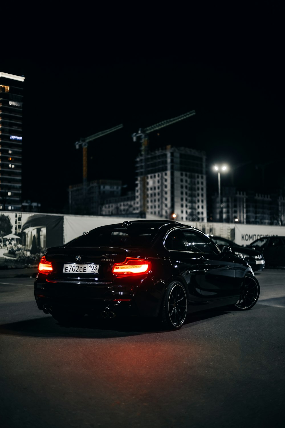 a black car parked in a parking lot at night