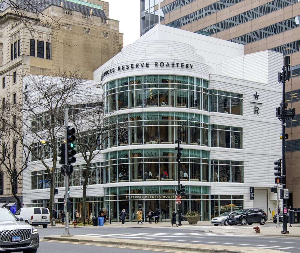 a large glass building on the corner of a street