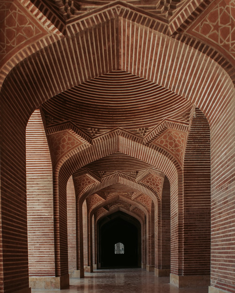 a long hallway with brick walls and arches