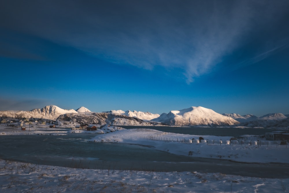 a snowy landscape with mountains in the background