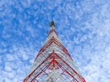 a very tall red and white tower under a blue sky