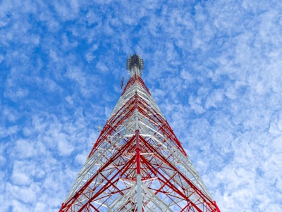 a very tall red and white tower under a blue sky