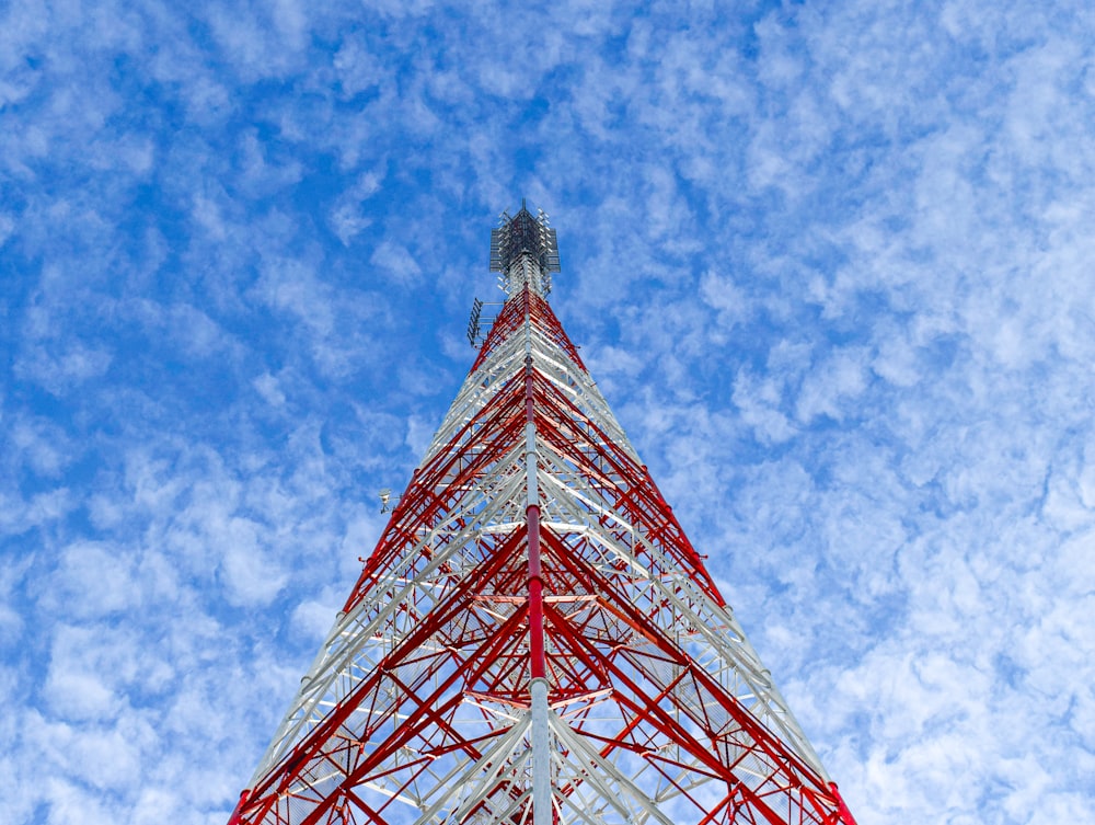 a very tall red and white tower under a blue sky