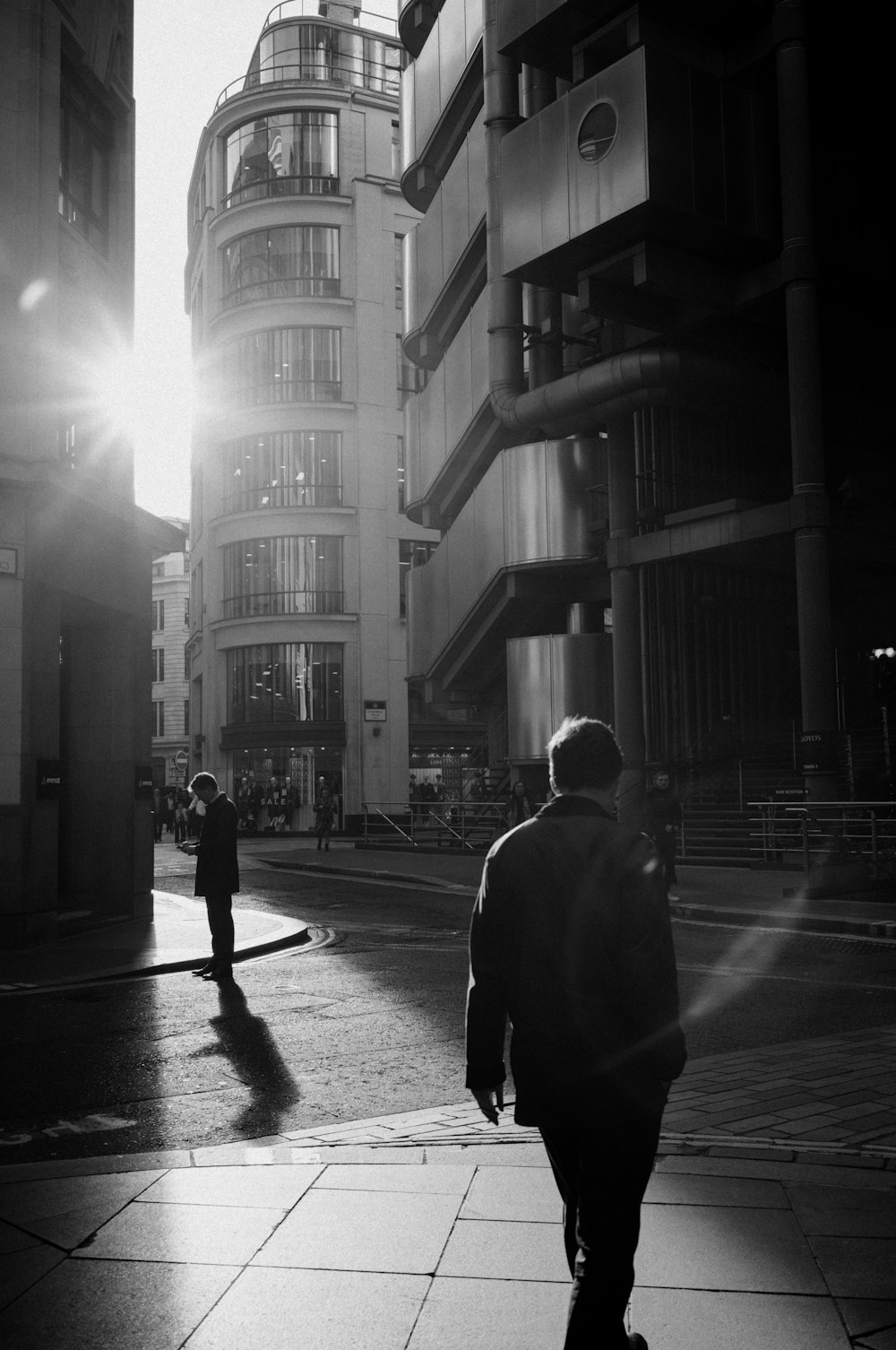 a man walking down a street next to tall buildings