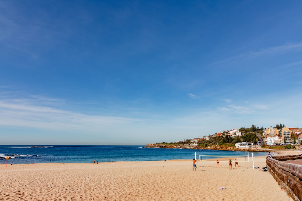 a beach with people playing volleyball on the sand